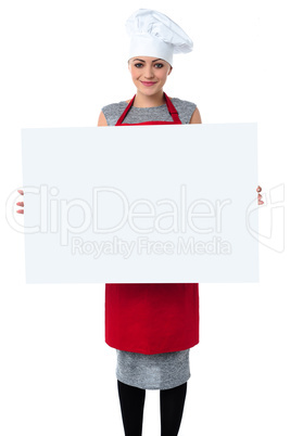 Young baker woman holding a blank whiteboard