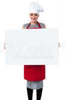 Young baker woman holding a blank whiteboard