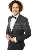 Young groom buttoning up his blazer