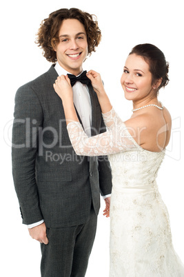 Pretty bride adjusting her man's bowtie