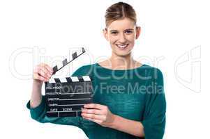 Young girl posing with clapperboard