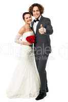 Groom with his bride showing thumbs up sign