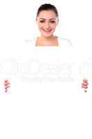 Smiling woman holding blank white ad board