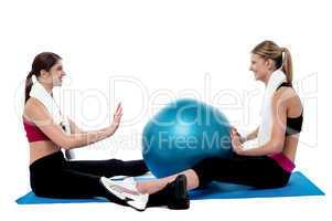 Fit women practicing an exercise with pilates ball