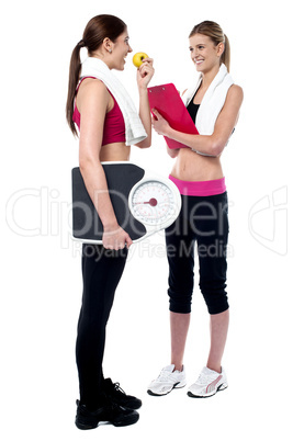 Female trainer writing diet chart for gym member