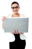 Bespectacled woman holding a laptop