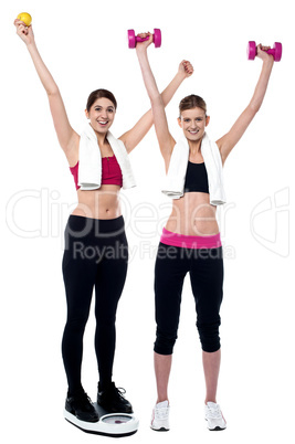 Two smiling girls working out together