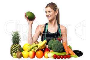 Attractive girl with heap of fruits and vegetables
