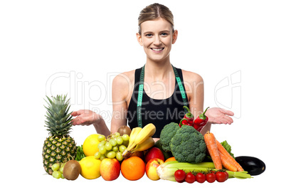 Young smiling girl presenting fresh fruits