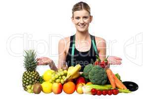 Young smiling girl presenting fresh fruits