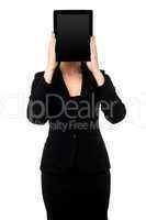 Woman hiding her face with tablet pc