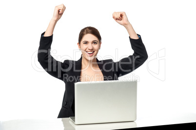 Excited businesswoman raising her arms up