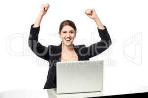 Excited businesswoman raising her arms up