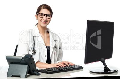 Smiling female doctor working on computer