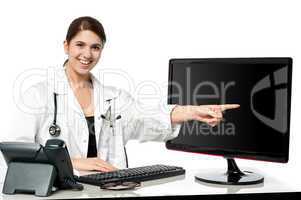 Female physician pointing at computer screen