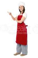 Female chef pointing towards copy space area