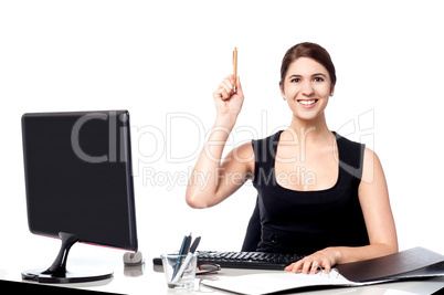 Businesswoman holding pen and raising her hand