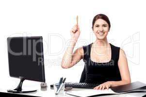 Businesswoman holding pen and raising her hand