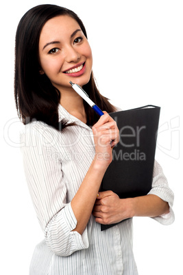 Female executive holding business file and pen