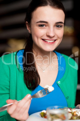 Happy young girl enjoying her dinner