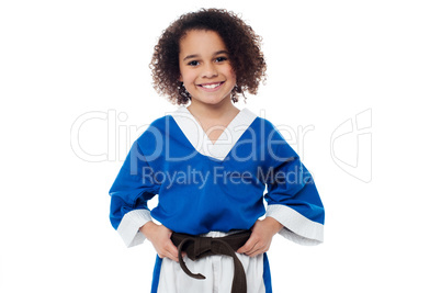 Little girl adjusting her brown karate belt
