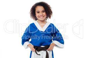 Little girl adjusting her brown karate belt