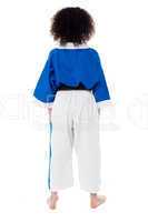 Back pose of a small girl in karate uniform