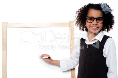 Young girl holding black marker pen, ready to write