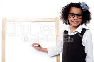 Young girl holding black marker pen, ready to write