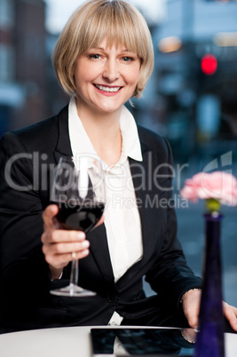 Happy businesswoman holding wine glass