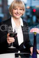 Happy businesswoman holding wine glass