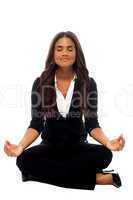 Businesswoman meditating in lotus posture