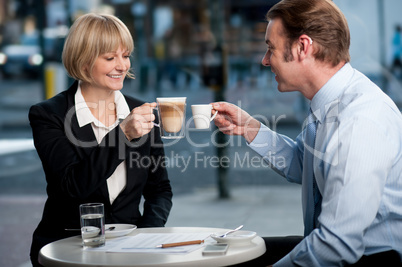 Business partners toasting coffee at cafe