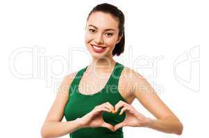 Pretty teenager making heart symbol with hands