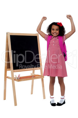 Excited beautiful little girl in school uniform