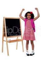 Excited beautiful little girl in school uniform