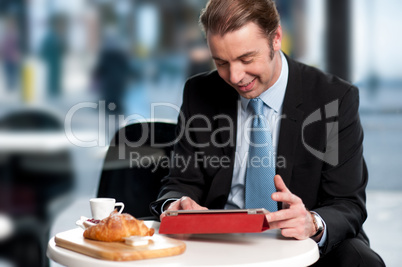 Male manager browsing internet on tablet device