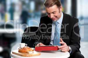 Male manager browsing internet on tablet device