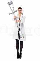 Smiling medical expert holding pair of crutches