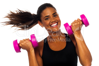 Happy fitness woman lifting dumbbells