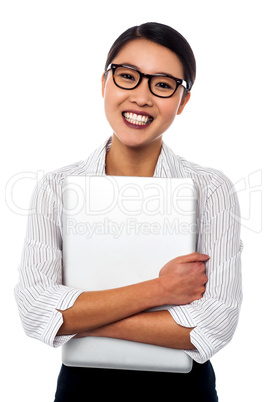 Female secretary holding laptop tightly