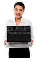 Smiling saleswoman presenting brand new laptop