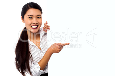 Business lady pointing towards ad on billboard