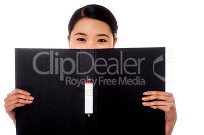 Chinese woman hiding face with business file