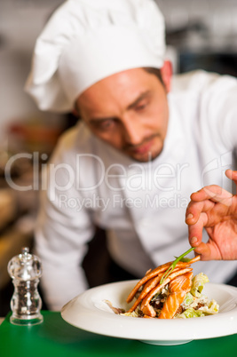 Professional chef preparing baked salmon to be served