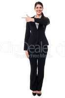 Attractive corporate woman pointing away