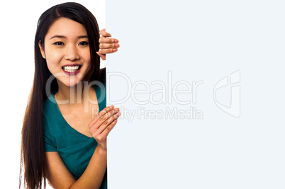 Asian girl holding blank white ad board