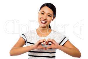 Pretty woman making heart symbol with hands