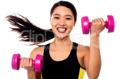 Happy fitness woman lifting dumbbells