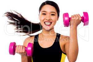 Happy fitness woman lifting dumbbells
